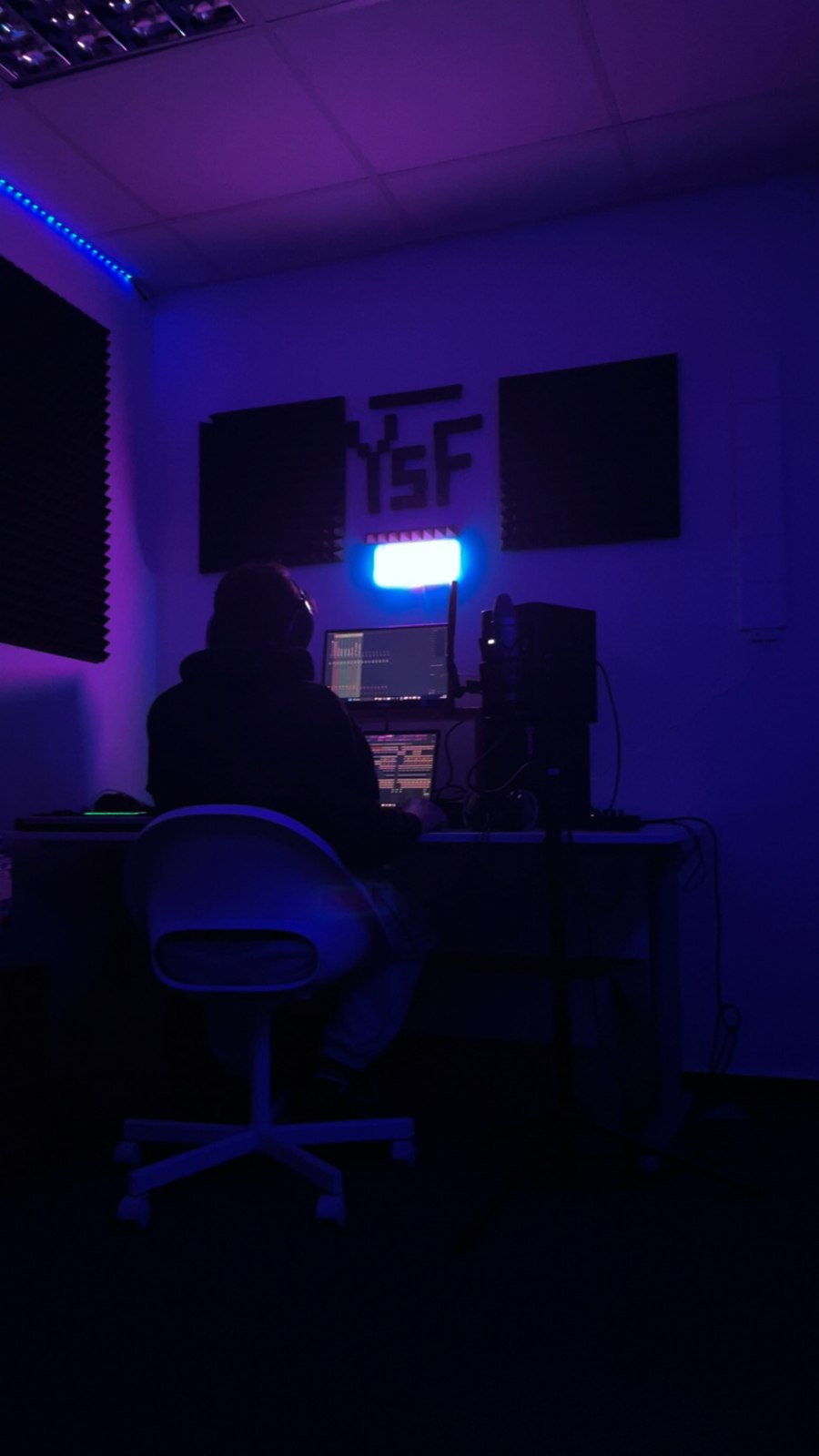 Eine Person am Studio-Arbeitsplatz unter violetter Beleuchtung