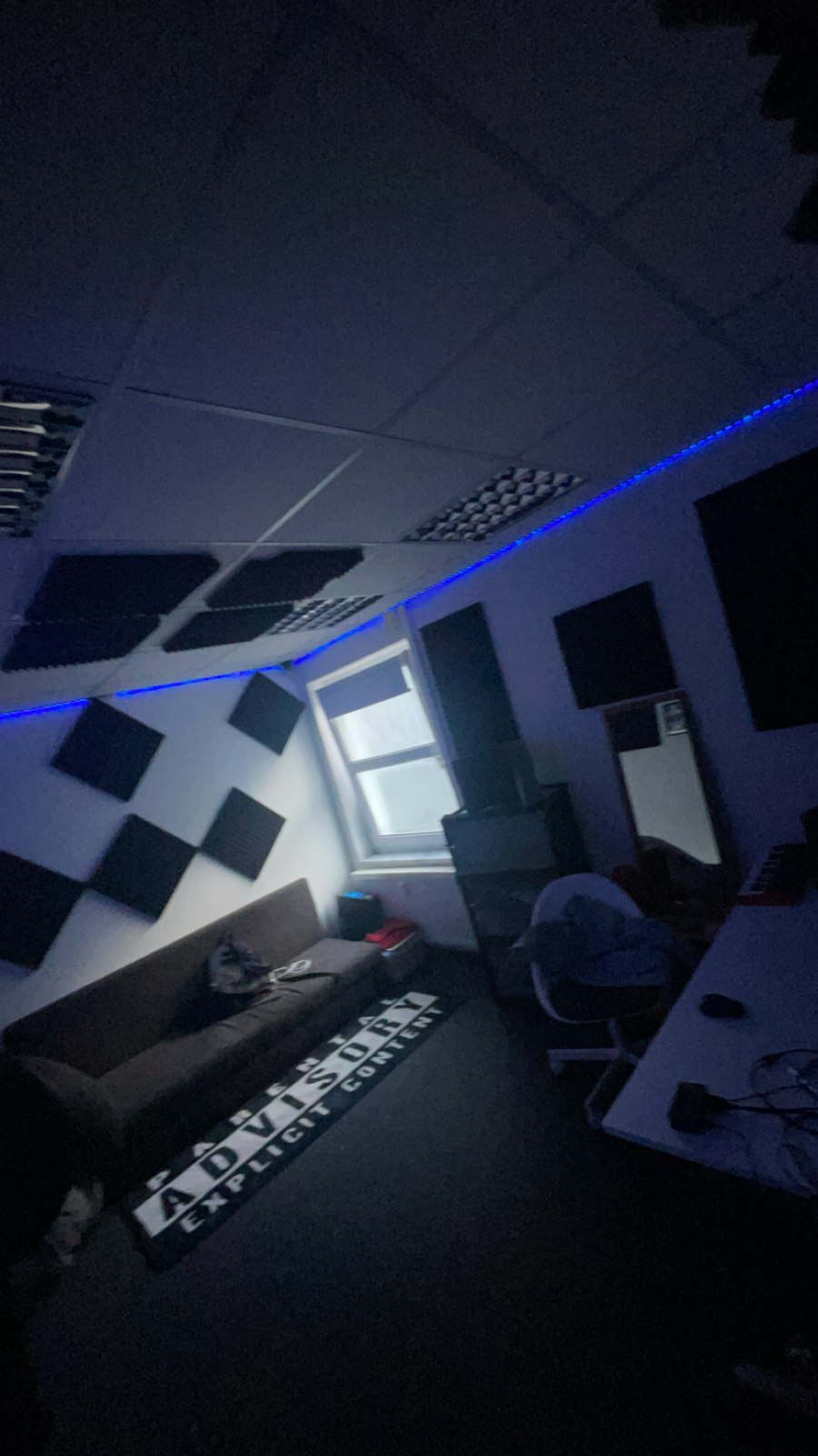 Studioraum mit Arbeitsplatz, Stuhl und Akustikpanelen an Wand und Decke